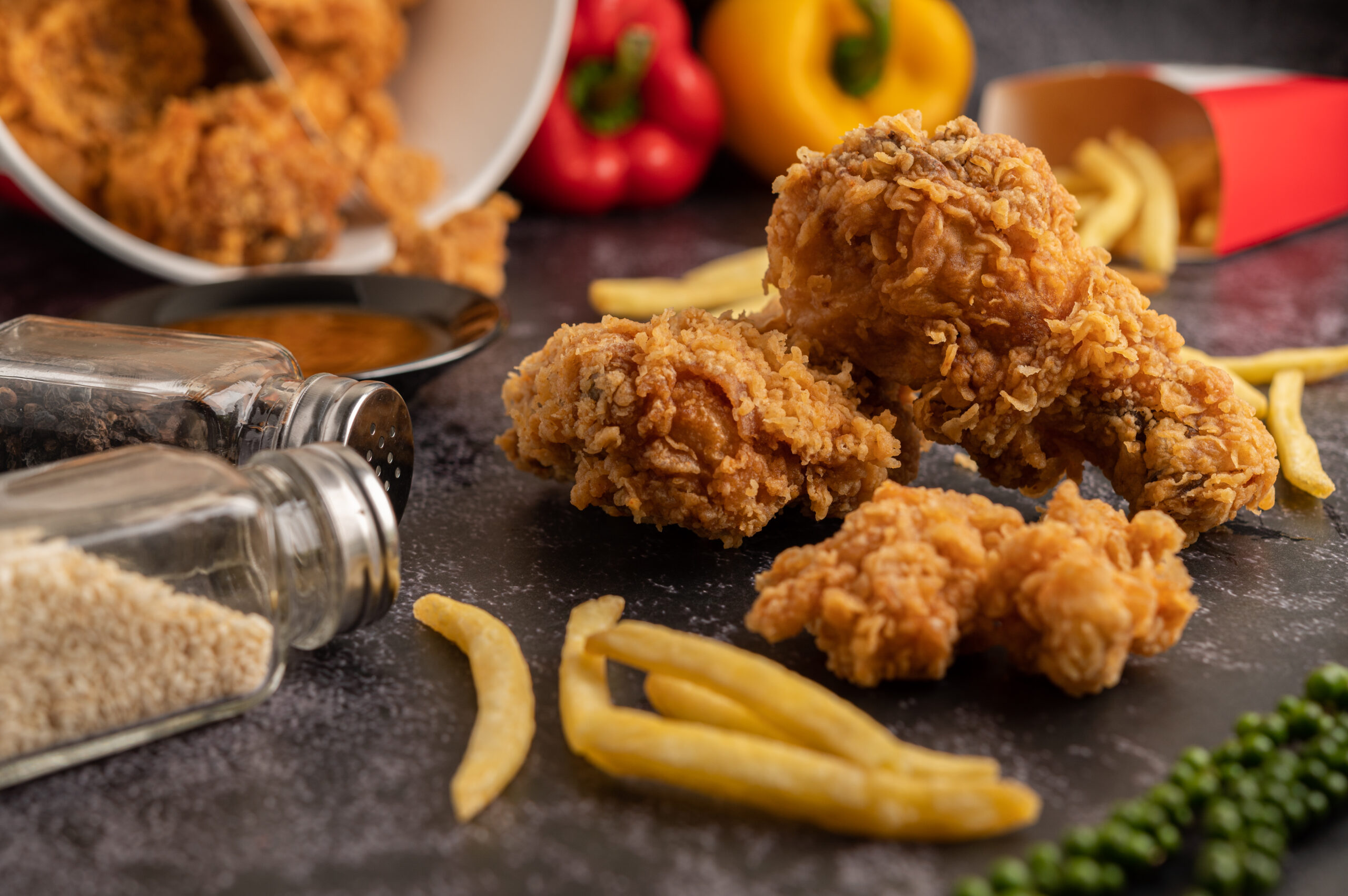 Fried Chicken and French Fries on Black Cement Floor.